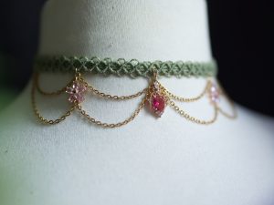 Collier ras de cou doré et vert avec des pendentifs rose