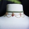 collier ras de cou avec un tissage vert , des chaines dorées et des pendentif fleur rose fait main par atelier de selene