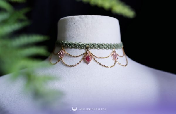 collier ras de cou avec un tissage vert , des chaines dorées et des pendentif fleur rose fait main par atelier de selene